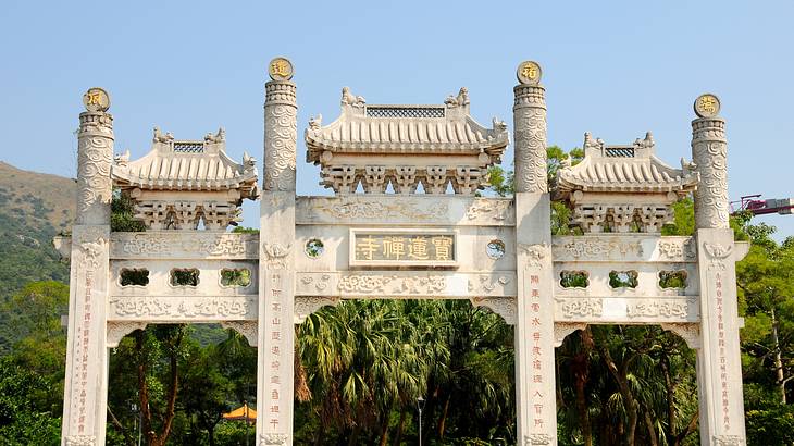 White entrance gate of a monastery, Lantau Island, Hong Kong White entrance gate of a monastery, Lantau Island, Hong Kong