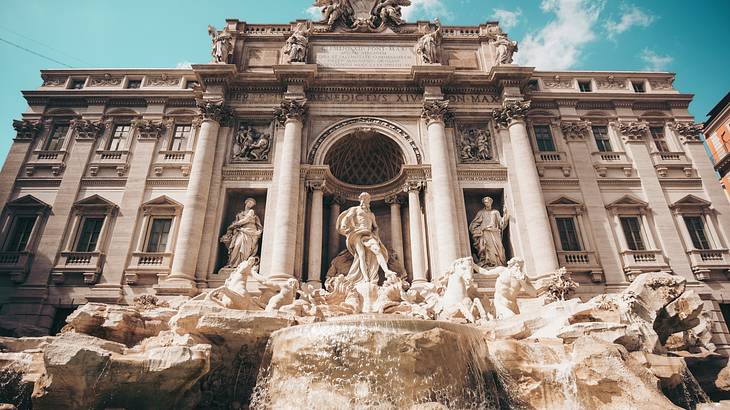 The grand and stunning Trevi Fountain with sculptures and water flowing down