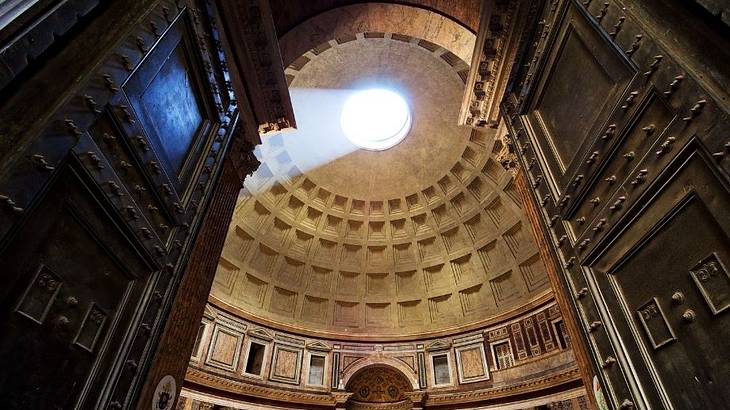 Sunlight shining through a circular hole at the top of a dome on a building