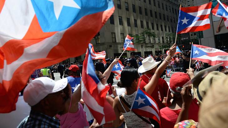 Supporters waving red, white and blue flags with a star in a crowded avenue Supporters waving red, white and blue flags with a star in a crowded avenue