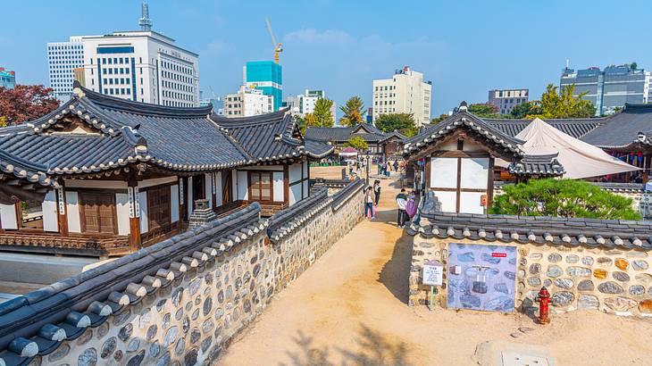 A small Korean village with houses and a path with cement walls running through it