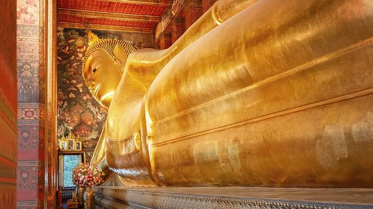 A gold reclining Buddha statue in a temple