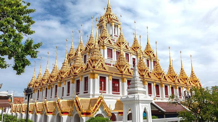 A white temple with gold spires under a cloudy sky