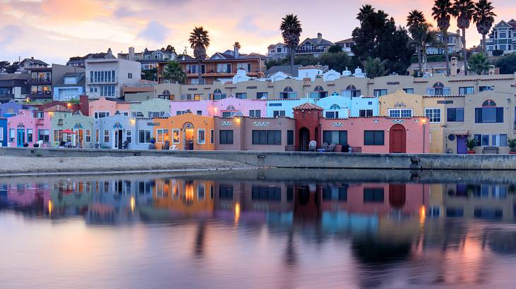 Colorful homes reflecting in still water during sunset
