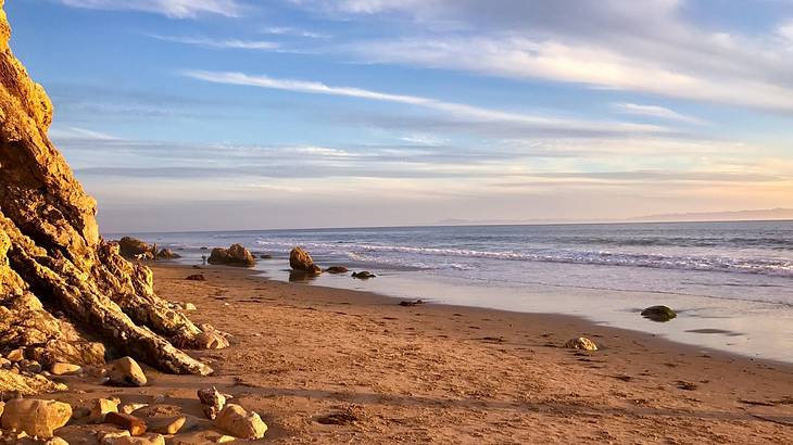 Waves crashing on a sandy rocky beach on a late afternoon Waves crashing on a sandy rocky beach on a late afternoon