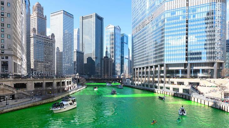 A green color river with boats winding through the downtown buildings