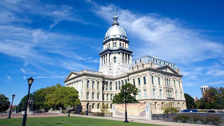A neoclassical capitol building with a dome under a partly cloudy sky A neoclassical capitol building with a dome under a partly cloudy sky