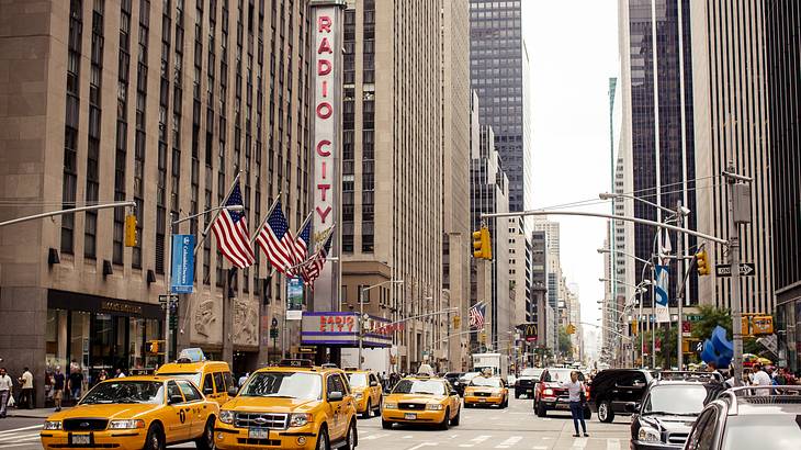 A building with Radio City sign and yellow taxis on the road in front