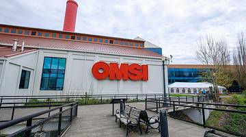 A white building with a red "OMSI" sign and a red chimney