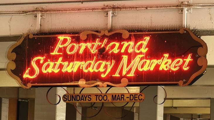 A sign that says "Portland Saturday Market" in red neon letters A sign that says "Portland Saturday Market" in red neon letters