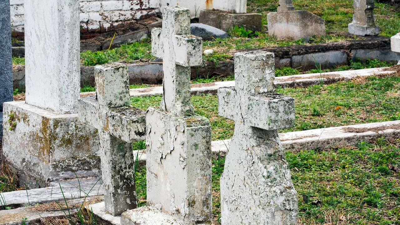 Stone crosses in a cemetery with grass around them