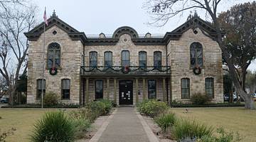 Limestone mansion at the end of a path walk surrounded by green grass