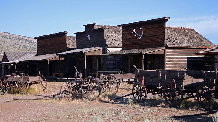 A ghost town with small wooden buildings and carts