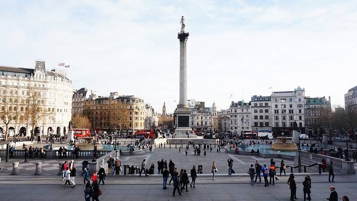 Busy day in Trafalgar Square, with Nelson's Column statue in the distance