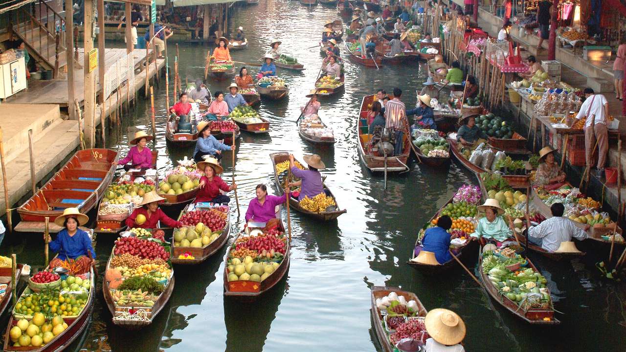 A floating market with people on small boats with produce in them