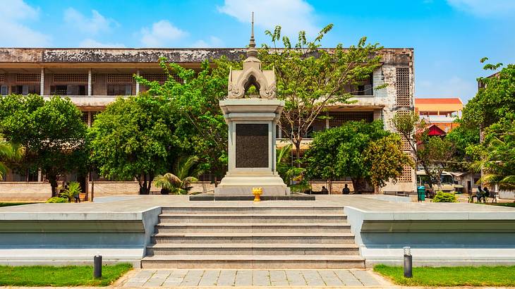 The exterior of a museum with steps and trees in front of it on a clear day