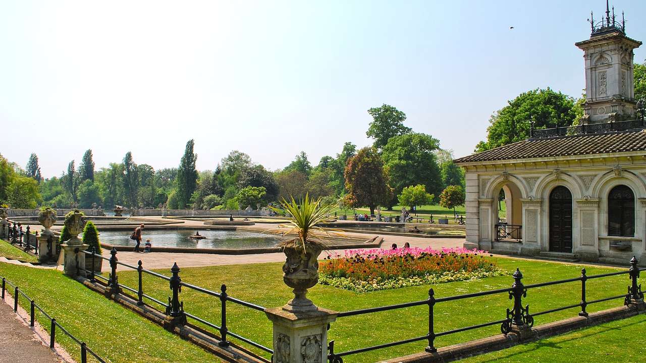 Italian-style gardens with flowers, green grass, and a pond