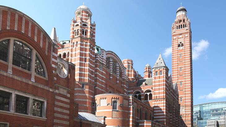 A red brick cathedral with white details and a few tall towers under a blue sky