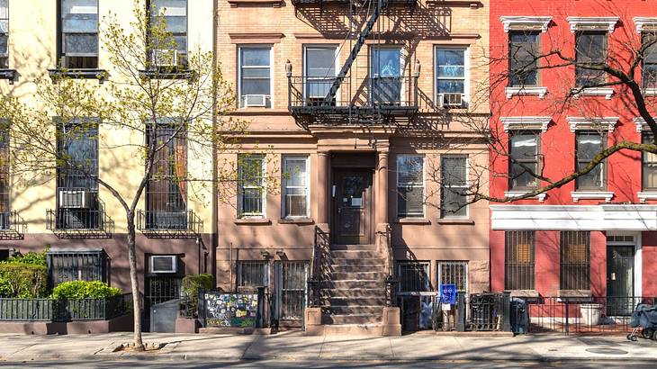 Brownstones as seen from the street with trees in front of them Brownstones as seen from the street with trees in front of them