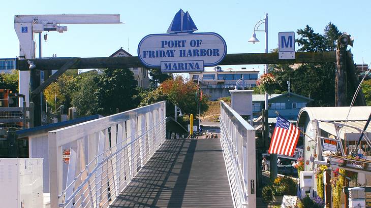 A bridge at a marina, a US flag, and a sign that says "Port of Friday Harbor Marina"