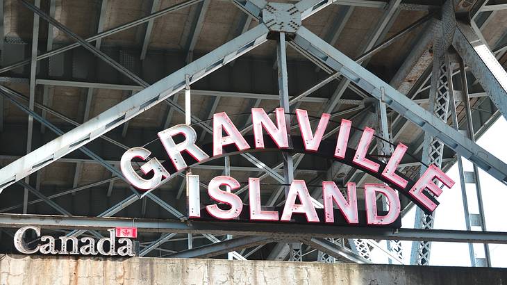 An iron sign that says "Granville Island" next to a small "Canada" sign