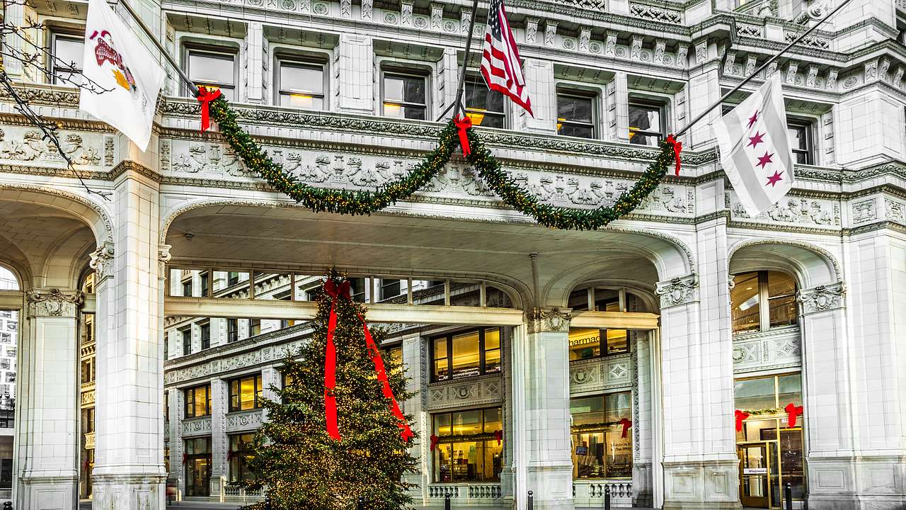 A building with a decorated tree in front of it and the US flag