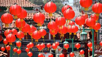 Up-close shot of Chinese red lanterns hanging over a street
