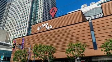 A modern building with a sign that says "SFMOMA" and an A in a red circle on the roof