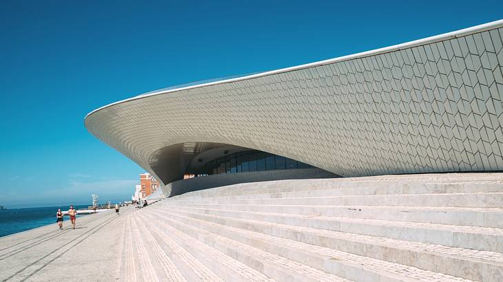 A modern structure next to steps and a clear blue sky