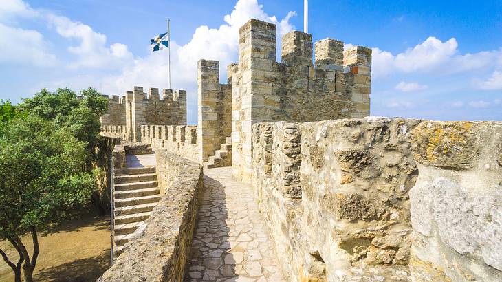 A stone castle with a flag on it next to green trees