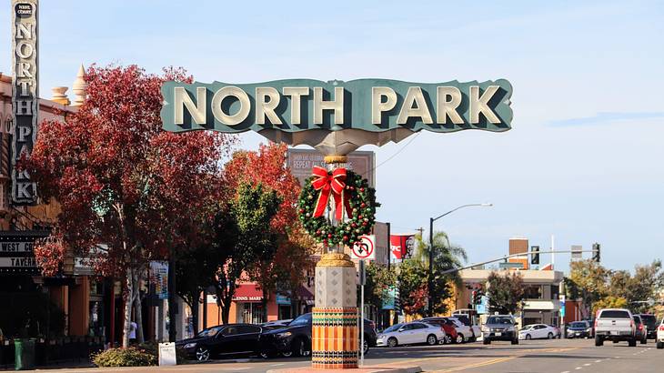 A sign "North Park" over a street with a Christmas wreath decoration