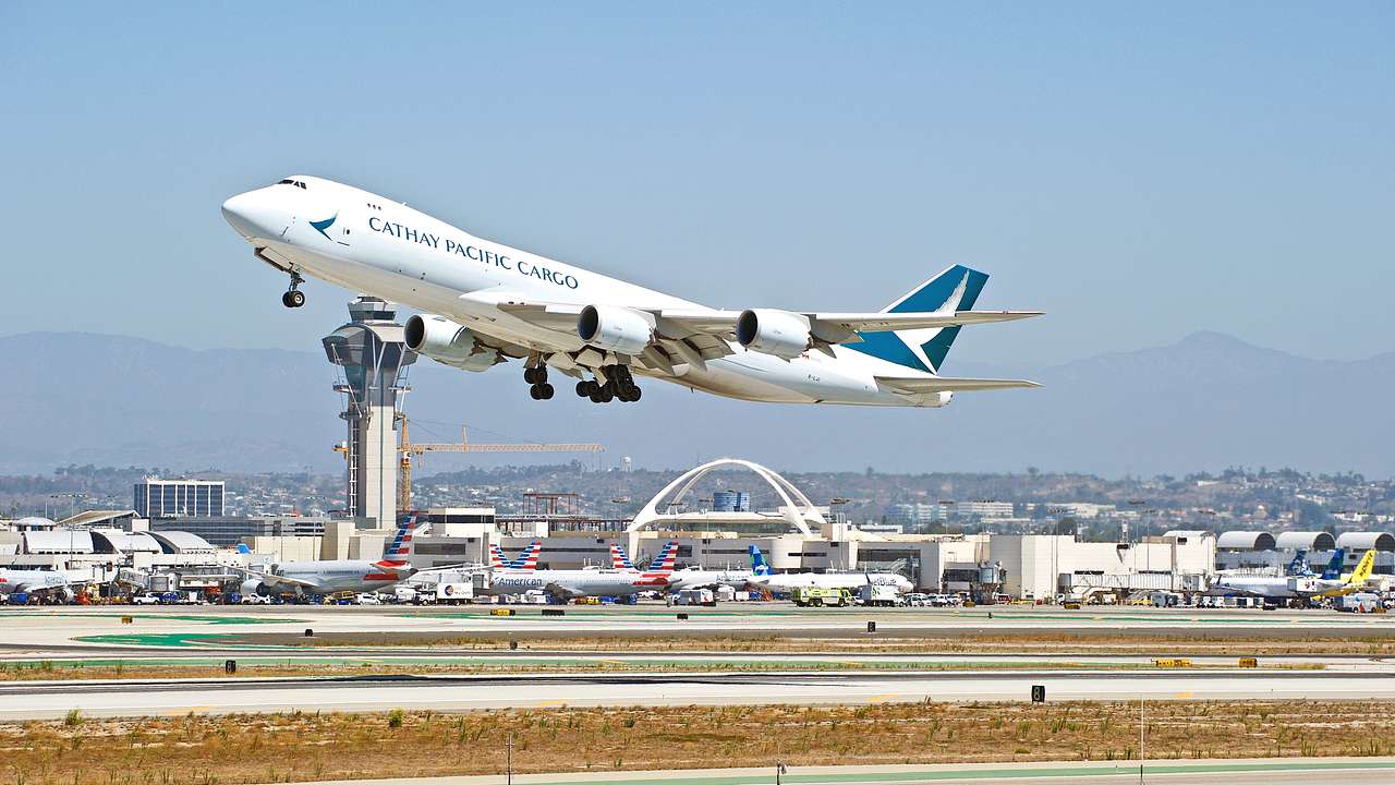 A large airplane taking off with the airport in the background