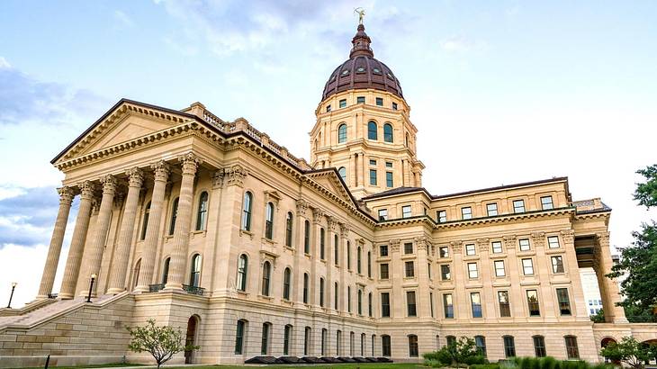 Looking up at a capitol building with columns and a black dome Looking up at a capitol building with columns and a black dome