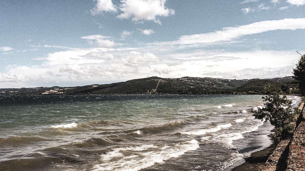 View of water, waves and hills in the background, Montefiascone, Italy