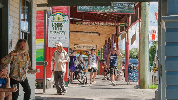 People walking on a street lined with stores on a sunny day