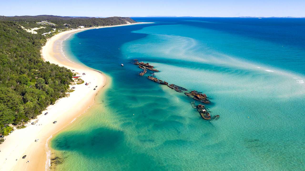 Aerial drone shot of blue water on white sandy shores on Moreton Island