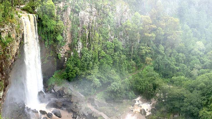 A waterfall gushing down into rocks in a forest