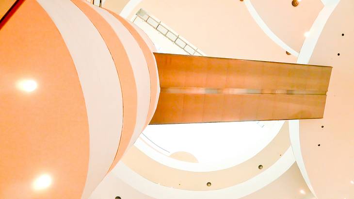 View from below of a museum's winding hallways, escalator, and stairs