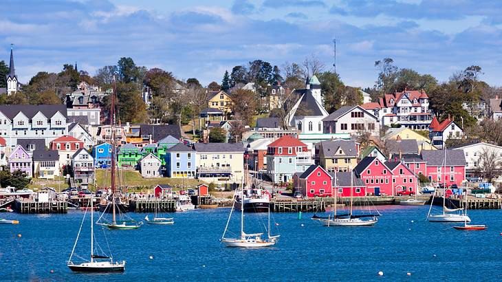 Fishing boats floating about with bright colorful wooden houses in the background