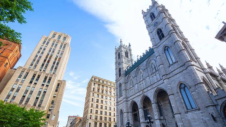 A Gothic-style building with two towers surrounded by other buildings