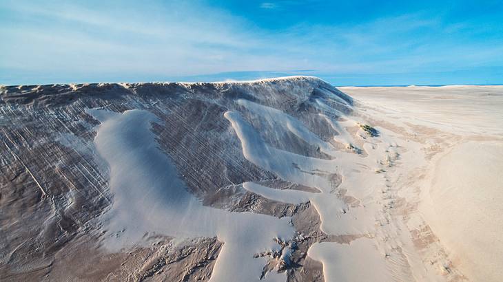 A hill of sand stretching endlessly on a sunny day