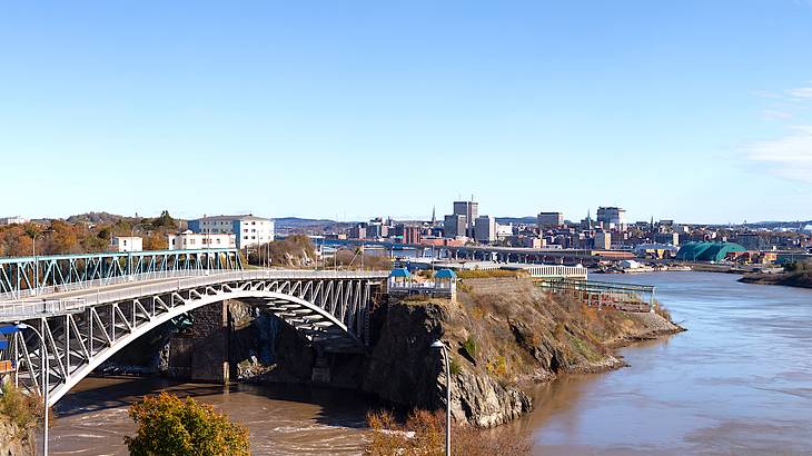 A bridge over a river with swirling water joining another body of water