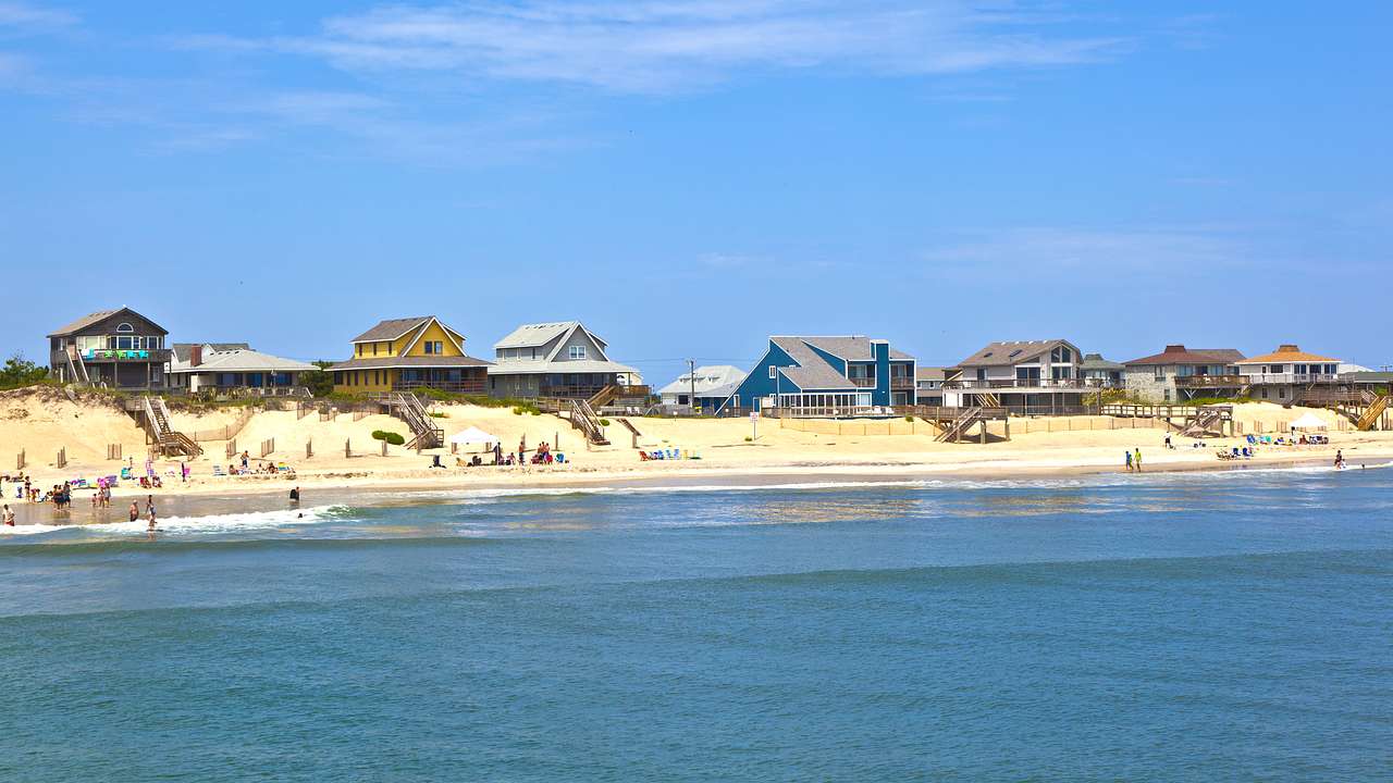 Beach houses in Outer Banks along the coastline facing the sea under a blue sky