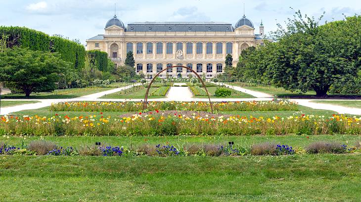 A museum building seen from afar with a beautiful garden in front