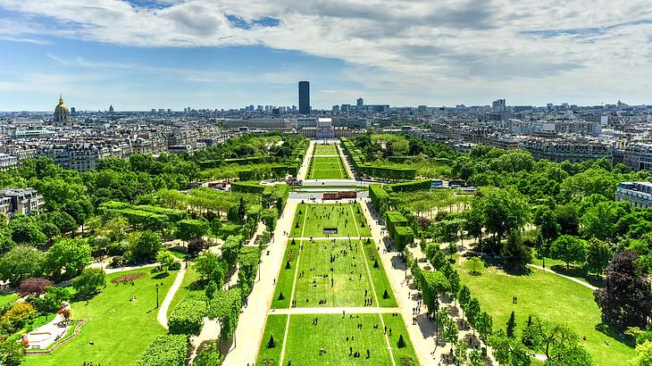 Aerial view of a vast green public park with a cityscape behind it