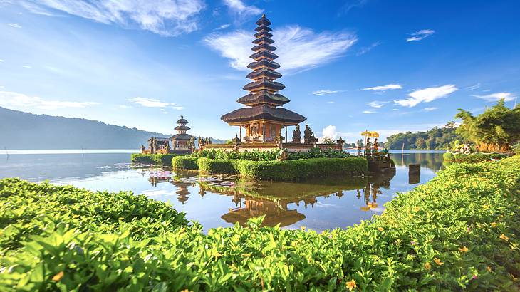 Temples surrounded by nature and water with a mountain behind