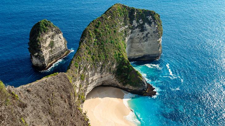 Aerial view of a stunning rock formation surrounded by sand and water