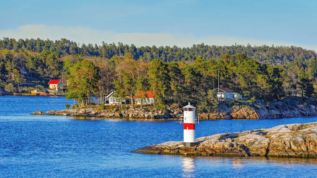 Islands with trees, a lighthouse, and small houses surrounded by water