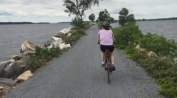 Best things to do in Burlington Vermont - Woman riding a bike on a pebbly path