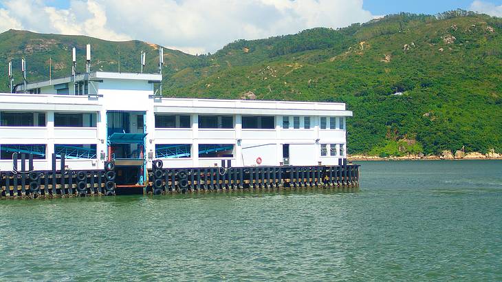 A pier with water and green hill in background, Mui Wo, Hong Kong A pier with water and green hill in background, Mui Wo, Hong Kong